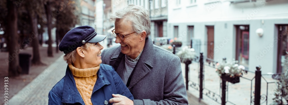 Older couple smiling at each other on a city sidewalk
